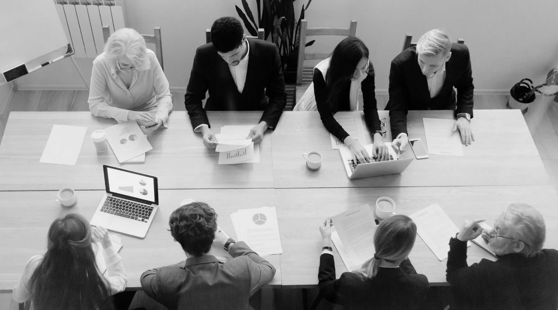 Craig Group Our People at the Table craig group overhead shot at the table our people in black and white