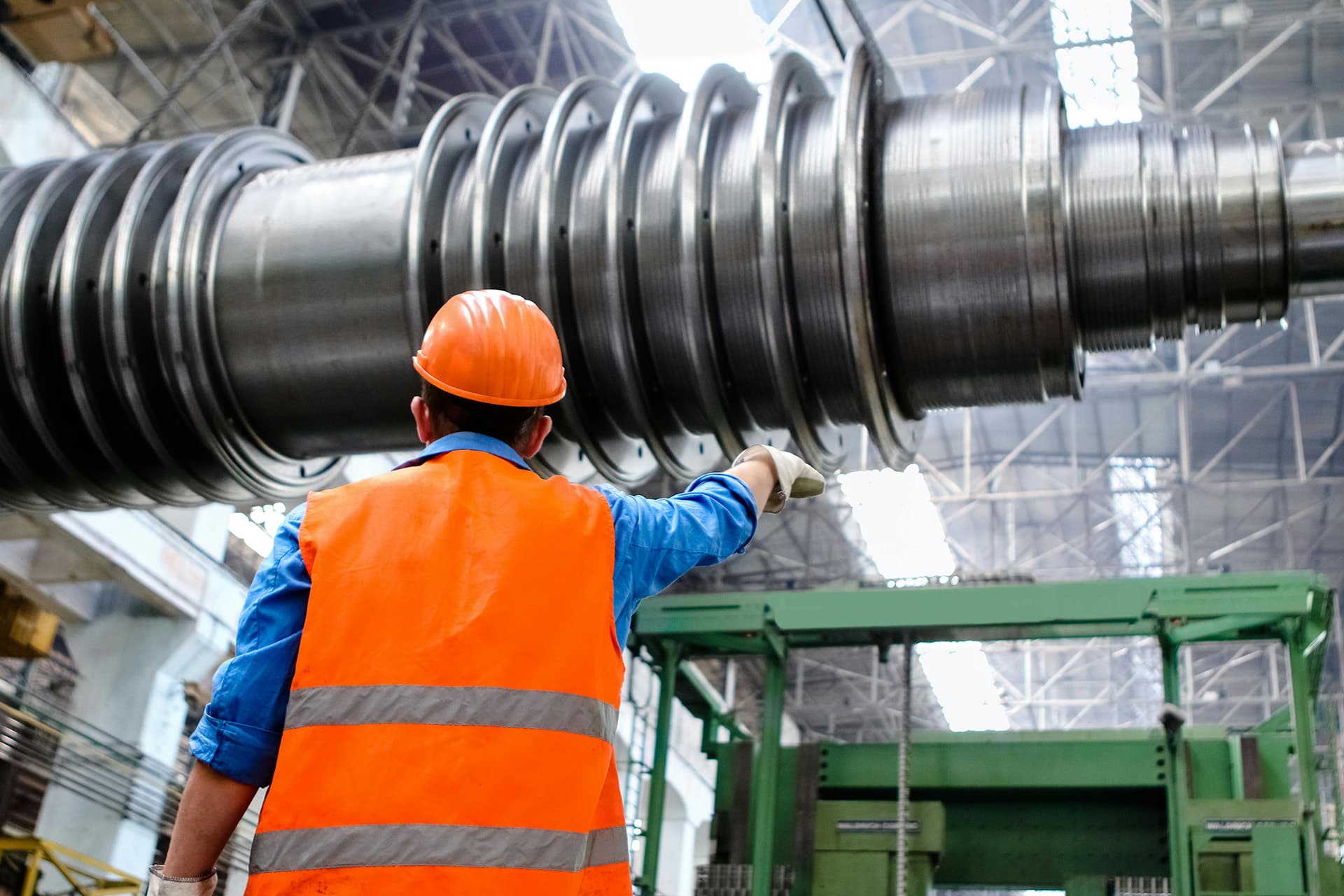 manufacturing_1920 A man standing underneath a piece of manufactured heavy machinery