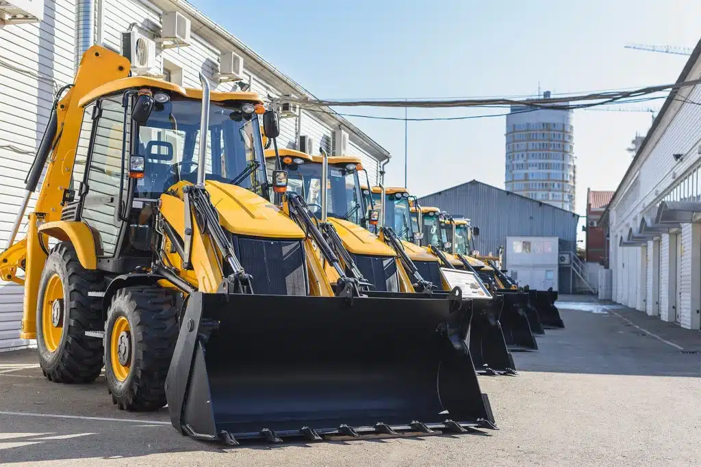 A lineup of yellow industrial excavators in an alley.