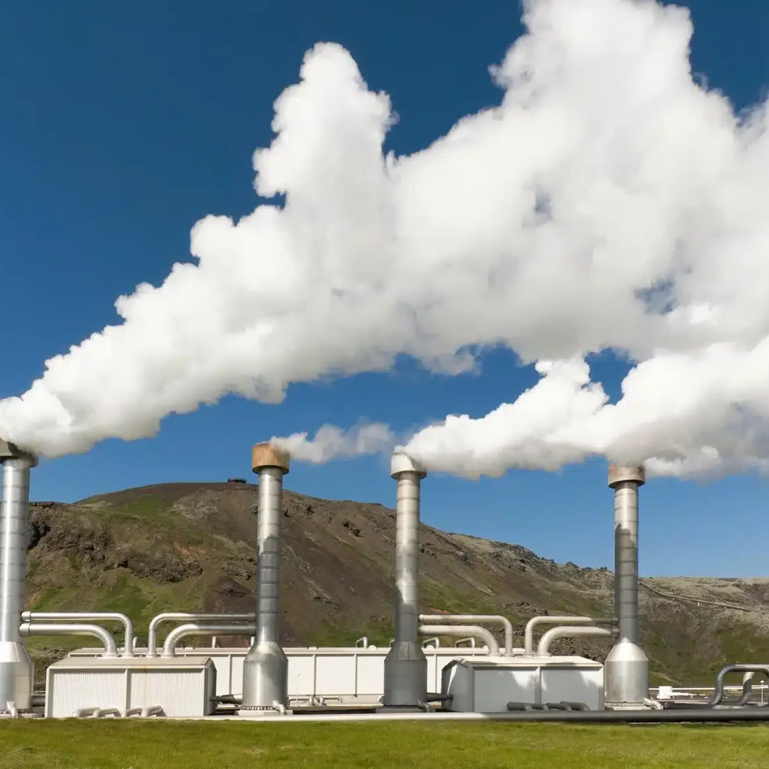A power plant with smoke billowing out of its stacks.